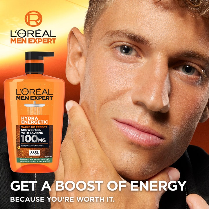L'Oréal Paris Men Expert Hydra Energetic Shower Gel 1000 ml oppkvikkende dusjsåpe i oransje pumpeflaske ved siden av en mann