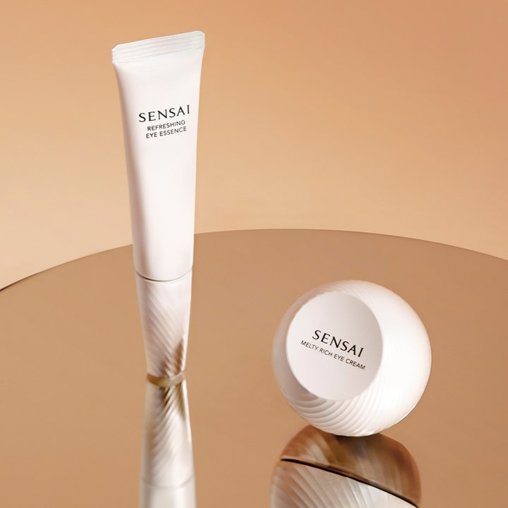 Sensai Refresh Eye Essence Refill 20 ml fuktighetsgivende øyekrem i hvit tube og krukke på en gyllen refleksjon