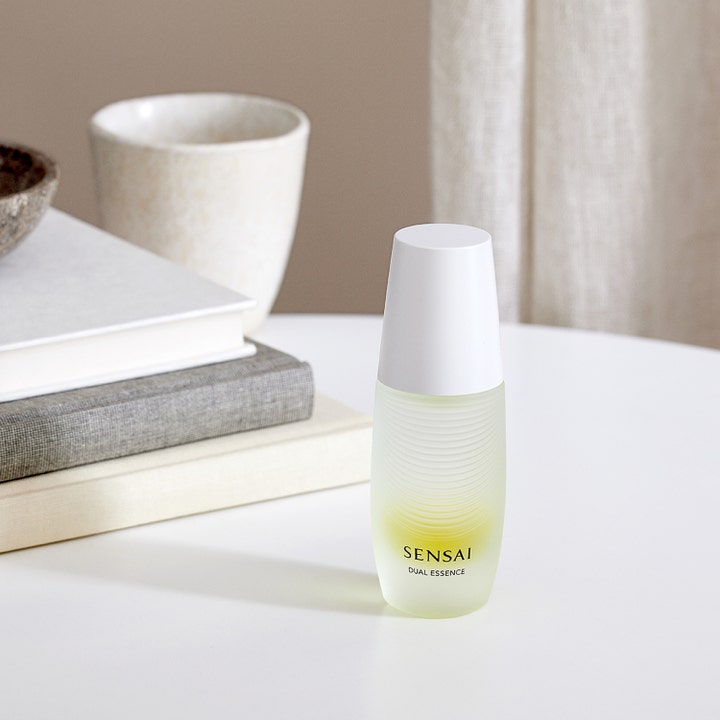 Sensai Dual Essence 30 ml fuktighetsgivende essence i frostet glassflaske med hvitt lokk i et lyst interiør.