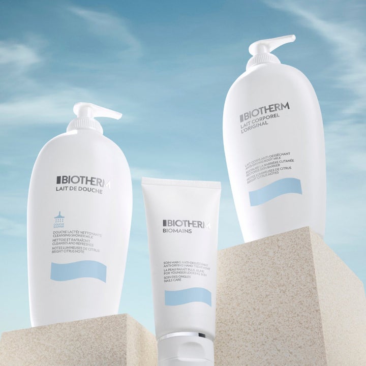 Biotherm Lait Corporel fuktighetsgivende sett med bodylotion, dusjkrem og håndkrem på steinsokler mot blå himmel.