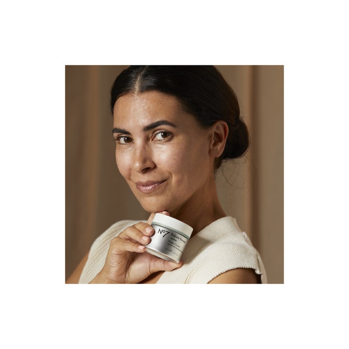 No7 Future Renew Repair Night Cream 50 ml reparerende nattkrem i sølvfarget krukke holdt av en kvinne.