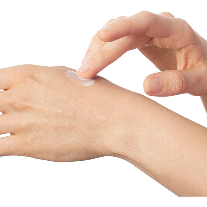 Heliocare Sensation SPF 50+ 50 ml beskyttende solkrem for ansiktet med en hvit og kremet tekstur på huden