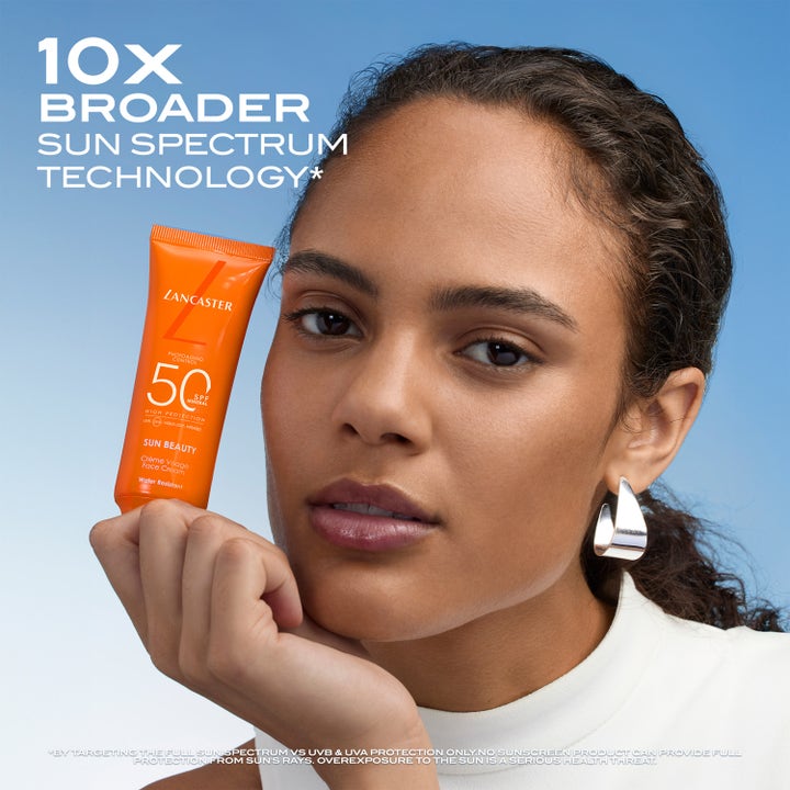 Lancaster Sun Beauty Face Cream SPF50 50 ml solkrem for ansikt holdt av kvinne mot blå bakgrunn