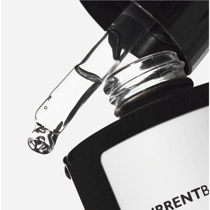Currentbody Skin Green Tea Serum 30 ml ansiktsserum med glasspipette som drypper klar væske over en svart flaske.