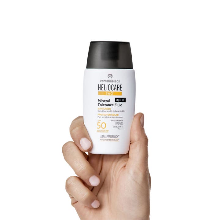 Heliocare Mineral Tolerance Fluid SPF 50 50 ml beskyttende solkrem med lett beige flytende tekstur i sirkelform.