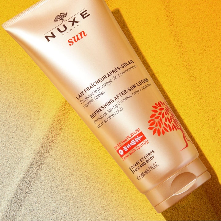 Nuxe Sun Refreshing After Sun Lotion 200 ml fuktighetskrem i bronsefarget tube på gyllen sand