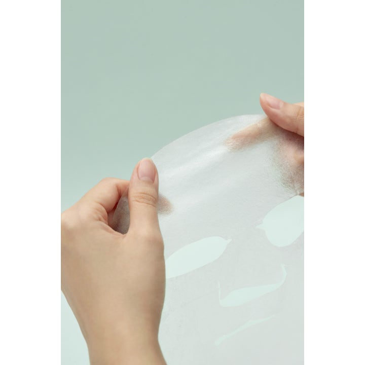I'm from Vitamin Tree Sheet Mask 1 stk ansiktsmaske som gir glød vist som en tynn hvit arkmaske mellom to hender