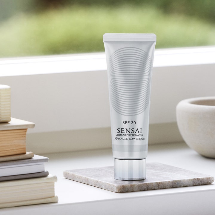Sensai Cellular Performance Advanced Day Cream 50 ml solkrem i sølvtube på marmorplate som gir SPF 30 beskyttelse