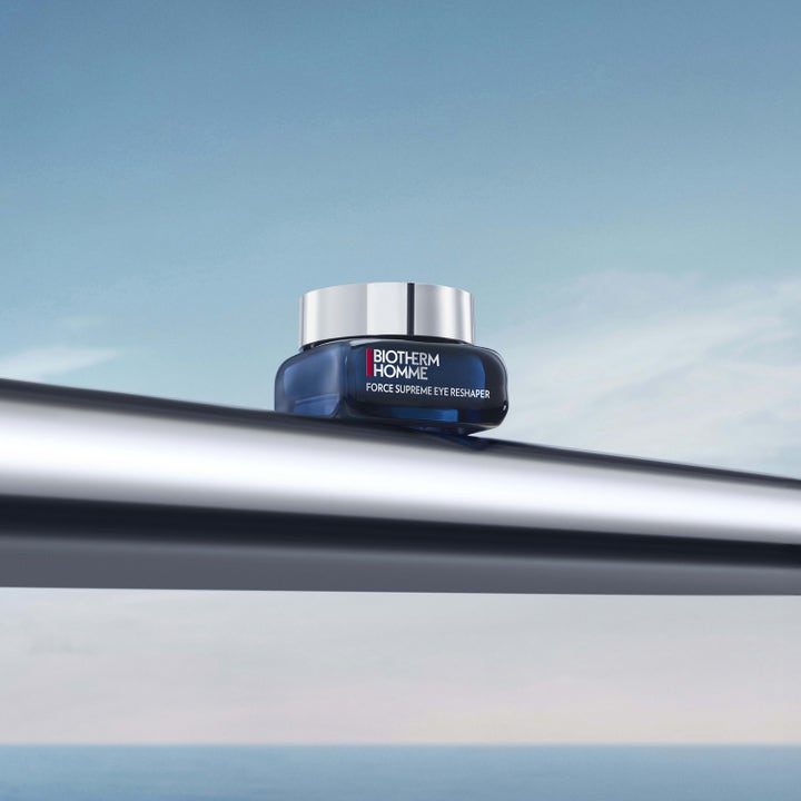Biotherm Force Supreme Eye Reshaper 20 ml øyekrem i mørkeblå krukke med sølvlokk mot en blå himmel.