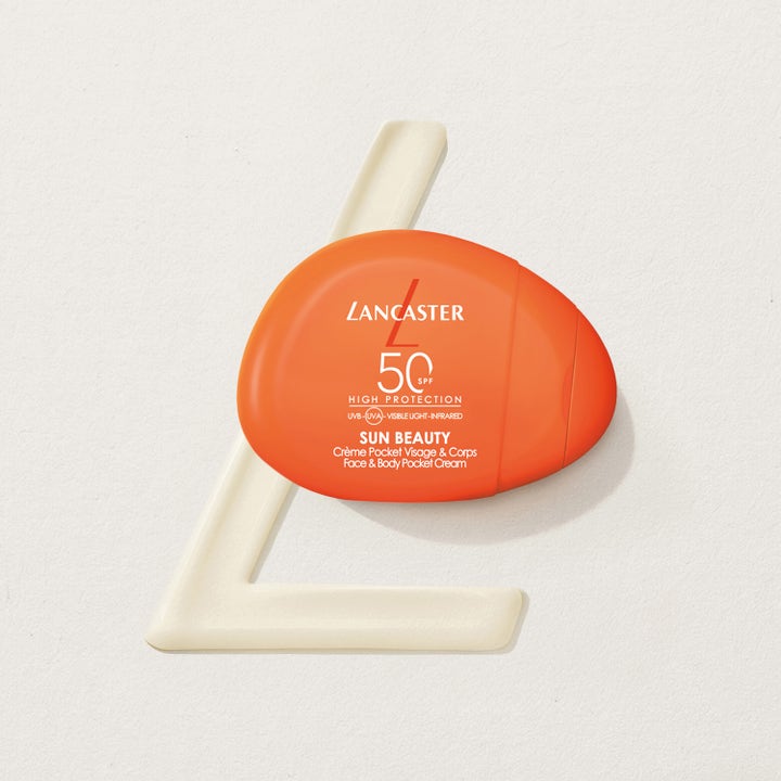 Lancaster Sun Beauty Face & Body Cream 30 ml gir SPF 50 beskyttelse i en oransje lommestørrelse-flaske på hvit bakgrunn.