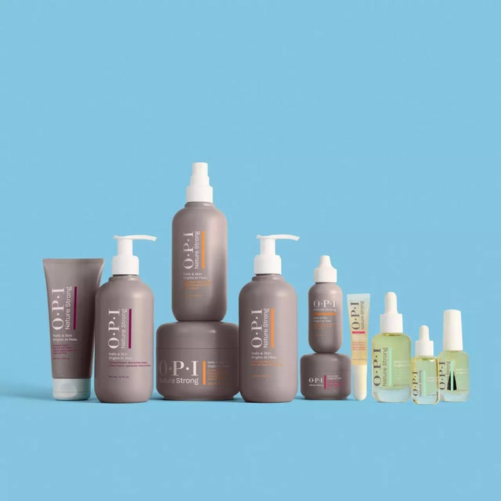 OPI Nature Strong Soften Up Pedi Soak 250 ml pleiende fotpleie vist i en samling av lilla og klare flasker.