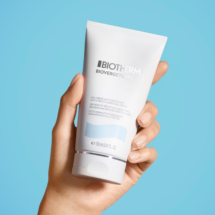 Biotherm Biovergetures 150 ml kremgelé mot strekkmerker i en hvit tube holdt av en hånd mot blå bakgrunn