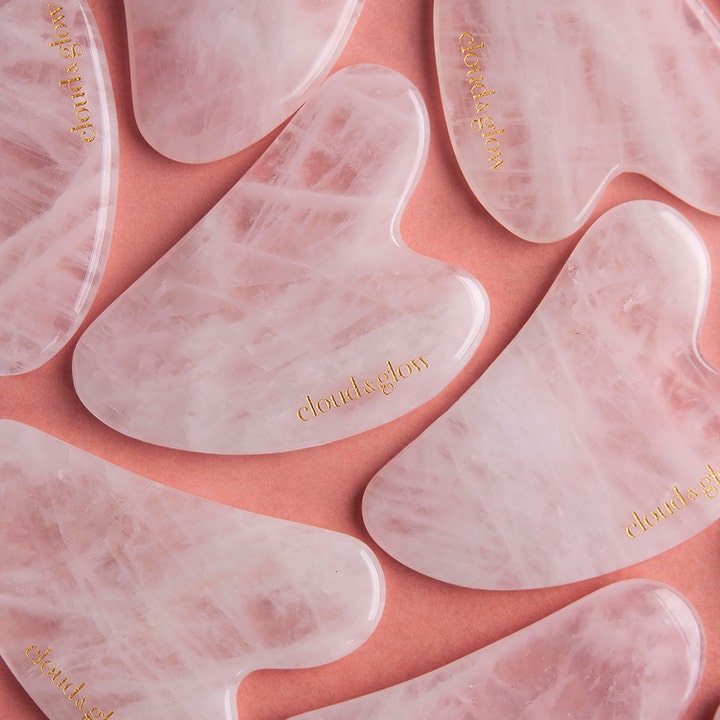 Cloud & Glow Rose Quartz Gua Sha 1 stk hudpleieverktøy i rosa marmorert stein med logo i gull.
