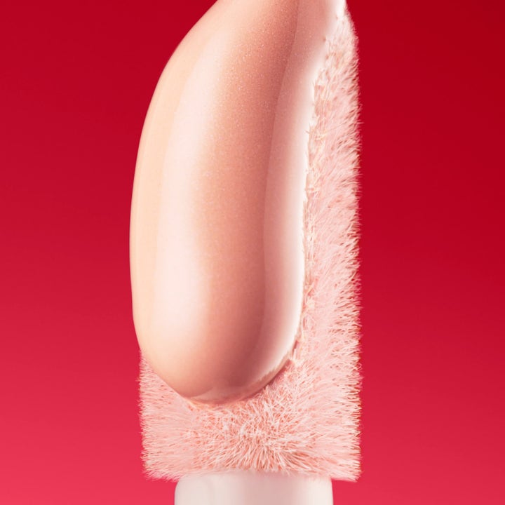 Nuxe Merveillance Lift Eye-Lighter Serum 12 ml øyeserum viser en glødende rosa tekstur på en myk børste.