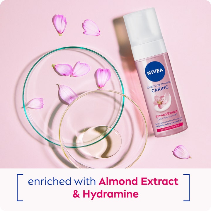 NIVEA Cleansing Mousse Caring 150 ml renseskum med mandelekstrakt og glasskåler på rosa bakgrunn