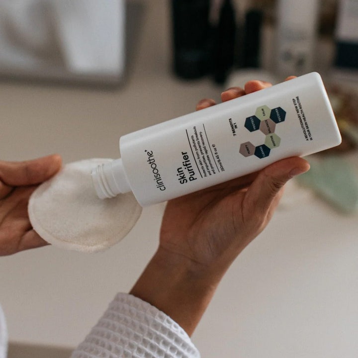Clinisoothe Skin Purifier 250 ml beroligende toner som påføres en hvit bomullspad fra hvit flaske.