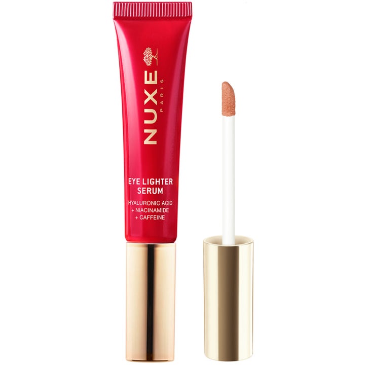 Nuxe Eye Lighter Serum opplysende øyeserum med niacinamid i rød tube med gullkork og ferskenfarget applikator.