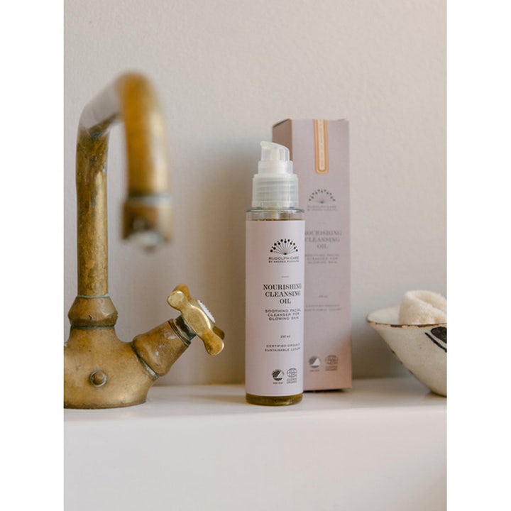 Rudolph Care Nourishing Cleansing Oil 100 ml pleiende ansiktsrengjøring i pumpeflaske ved en messingkran
