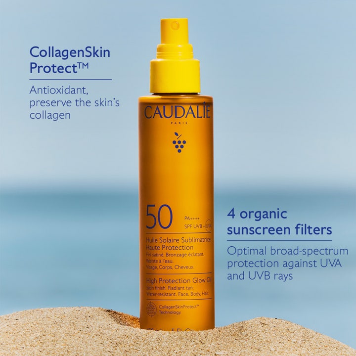 Caudalie Vinosun High Protection Glow Oil 150 ml sololje med SPF 50 og CollagenSkin Protect i gul sprayflaske i sand.