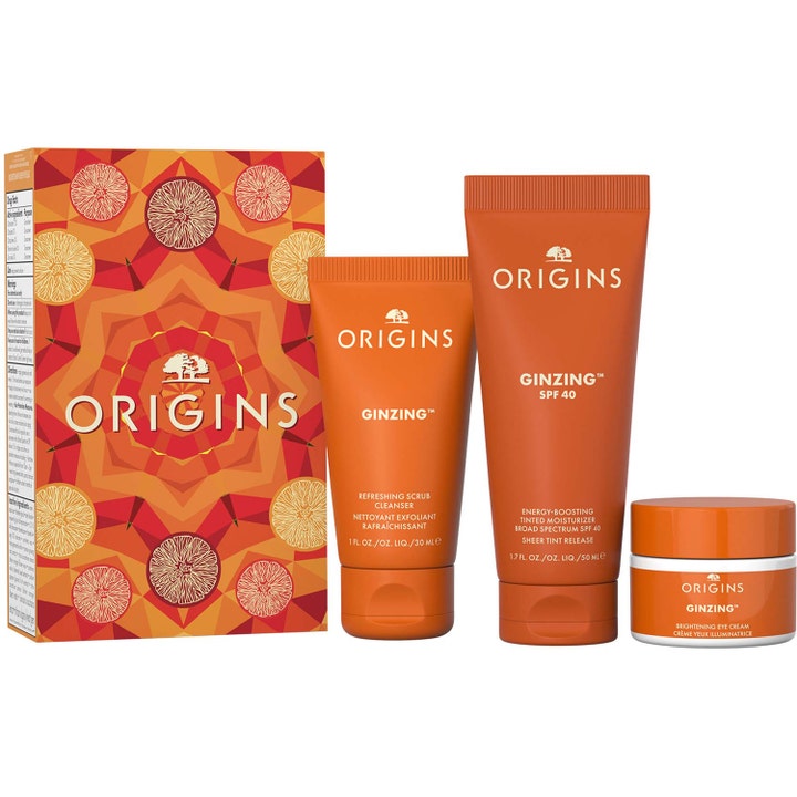 Origins GinZing sett med rens 30 ml og krem 50 ml som gir glød i oransje tuber og hvit krukke foran en mønstret eske