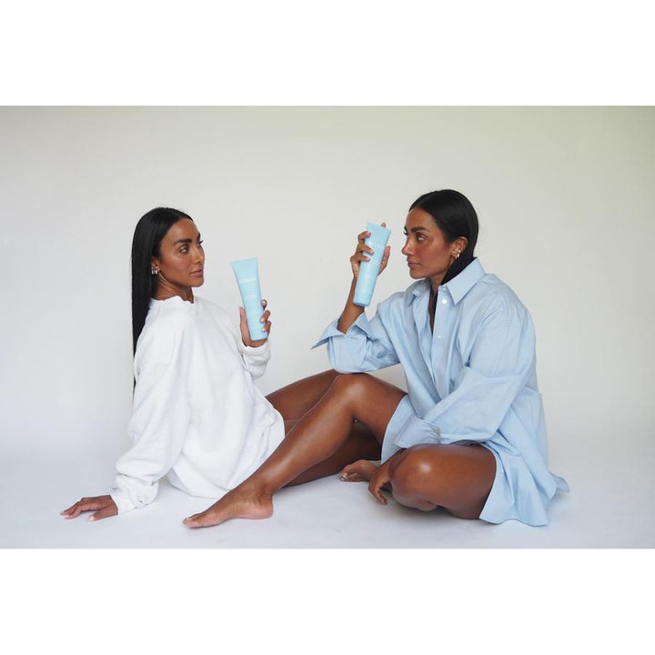 MASHH Gentle Moist Body Lotion 300 ml fuktighetskrem i blå tube holdes av to kvinner i en lys setting