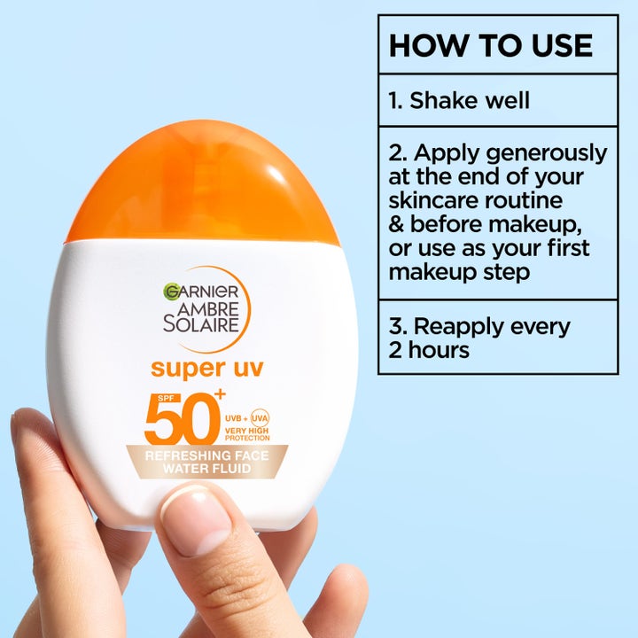 Garnier Ambre Solaire Super UV Water Fluid 40 ml solkrem for ansiktet SPF 50+ i hvit flaske med bruksanvisning