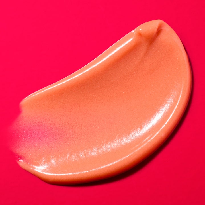 Nuxe Merveillance Lift Glow 50 ml dagkrem med en glødgivende ferskenfarget kremtekstur mot en rosa bakgrunn.