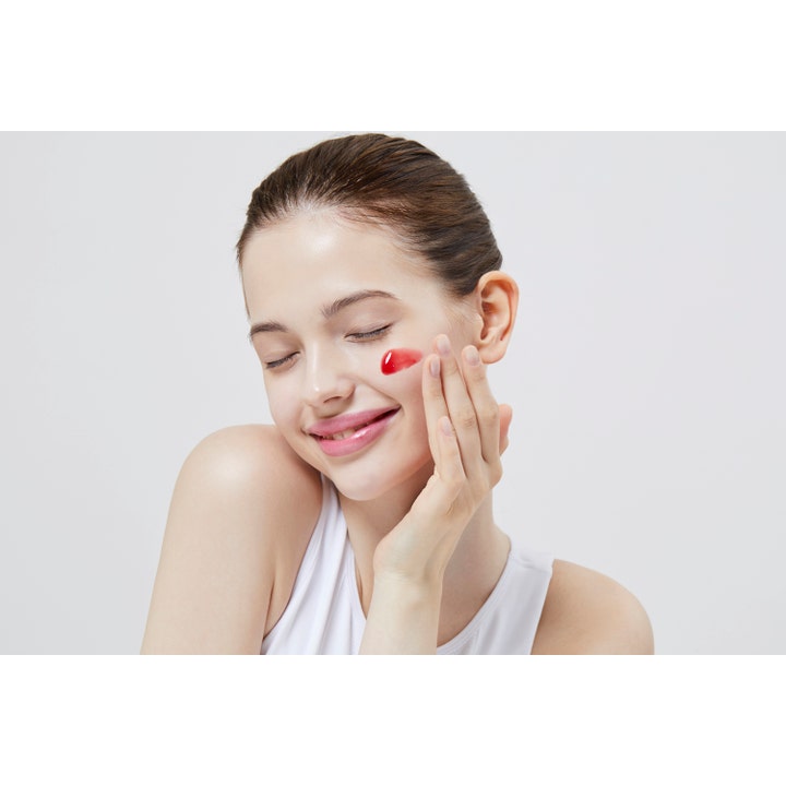 COSRX The AHA BHA PHA LHA 35 Peel 30 ml eksfolierende peeling med rød tekstur påført en kvinnes hud.
