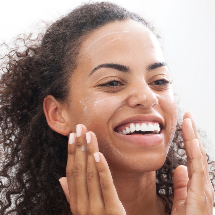 Clinique All About Clean Liquid Facial Soap Mild 200 ml rengjøringsgel påføres som en hvit krem av en smilende kvinne