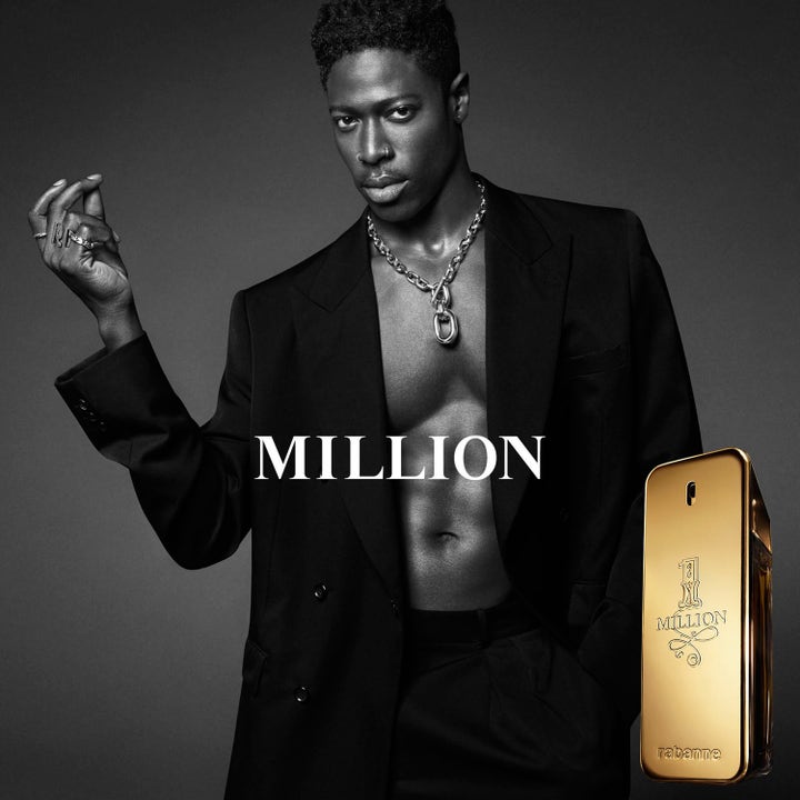 Rabanne 1 Million 75 ml deostick i gullfarget hylse ved siden av en mann i sort dressjakke.