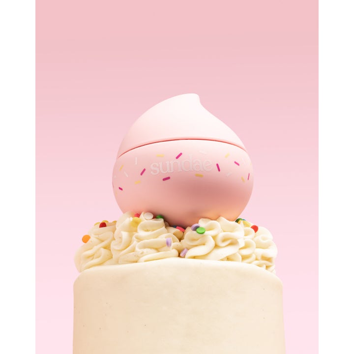 Sundae Whipped Body Moisturiser Birthday Cake 220 ml fuktighetskrem i rosa krukke plassert på en kake.