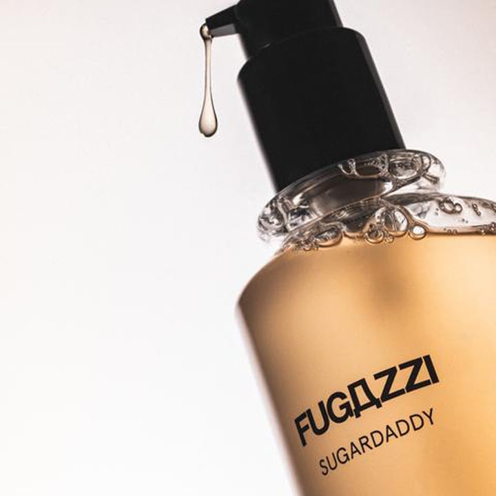 Fugazzi Sugardaddy Body Wash 250 ml luksuriøs dusjsåpe med gyllen tekstur og en hengende dråpe fra pumpen.