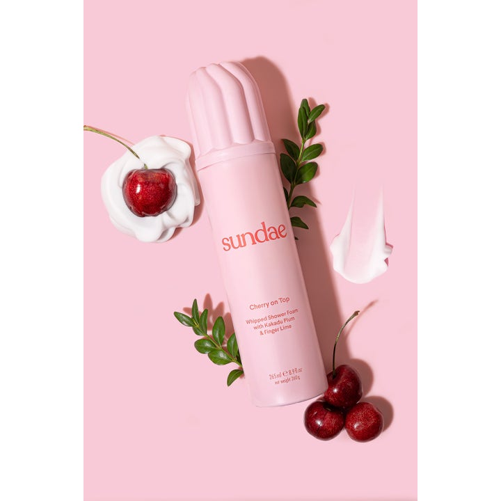 Sundae Whipped Shower Foam Cherry On Top 265 ml pleiende dusjskum i rosa flaske omgitt av friske kirsebær