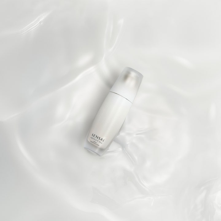 Sensai Absolute Silk Micro Essence-In-Lotion 125 ml fuktighetsgivende serum i rillet hvit flaske på silkemyk bakgrunn