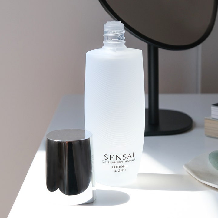 Sensai Cellular Performance Lotion I Light 125 ml ansiktsvann gir fukt i hvit frostet flaske med sølvkork ved siden av.