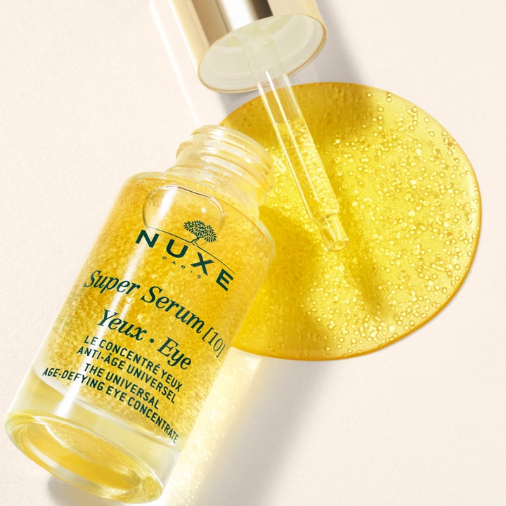 Nuxe Super Serum [10] Eye 15 ml anti-age øyenserum i glassflaske med gyllen geltekstur og mikrokuler.