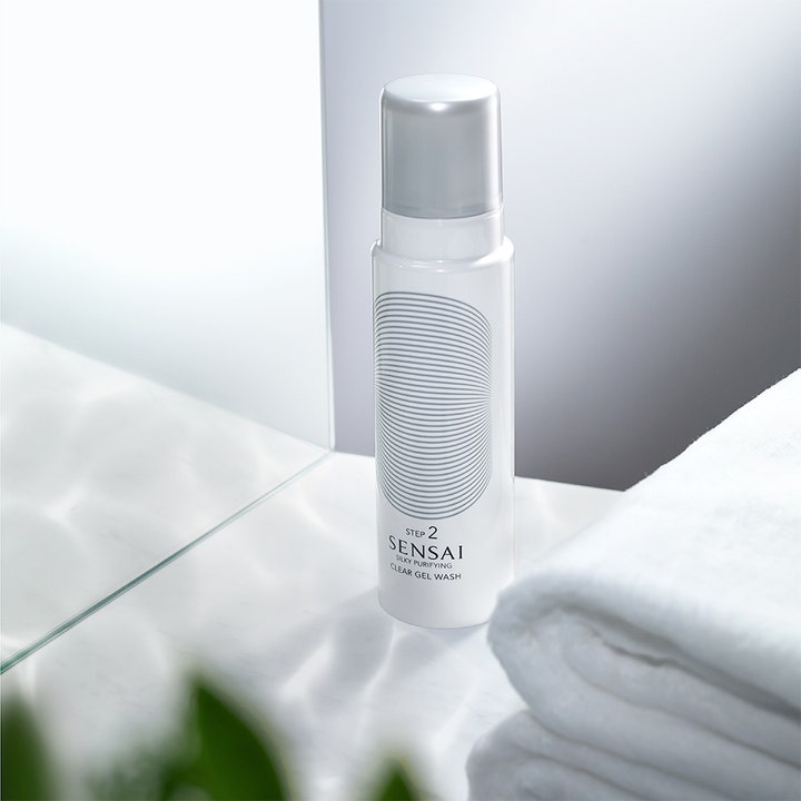 Sensai Silky Purifying Clear Gel Wash 145 ml Step 2 rengjøringsgel i hvit flaske ved et hvitt håndkle på badet.