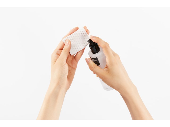 COSRX BHA Blackhead Power Liquid 100 ml eksfolierende toner som pumpes fra frostet flaske over på en hvit bomullspad