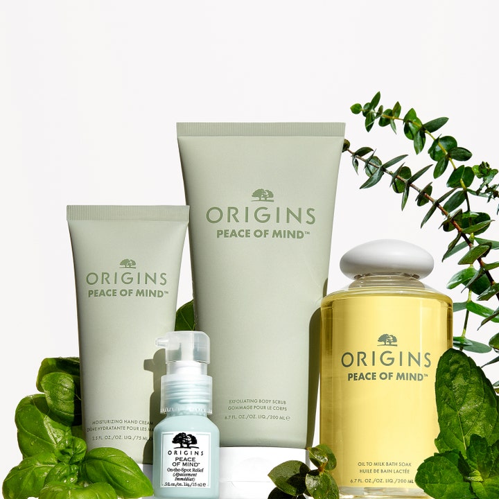 Origins Peace Of Mind Moisturizing Hand Cream 75 ml fuktighetsgivende håndkrem ved siden av andre produkter og grønne blader