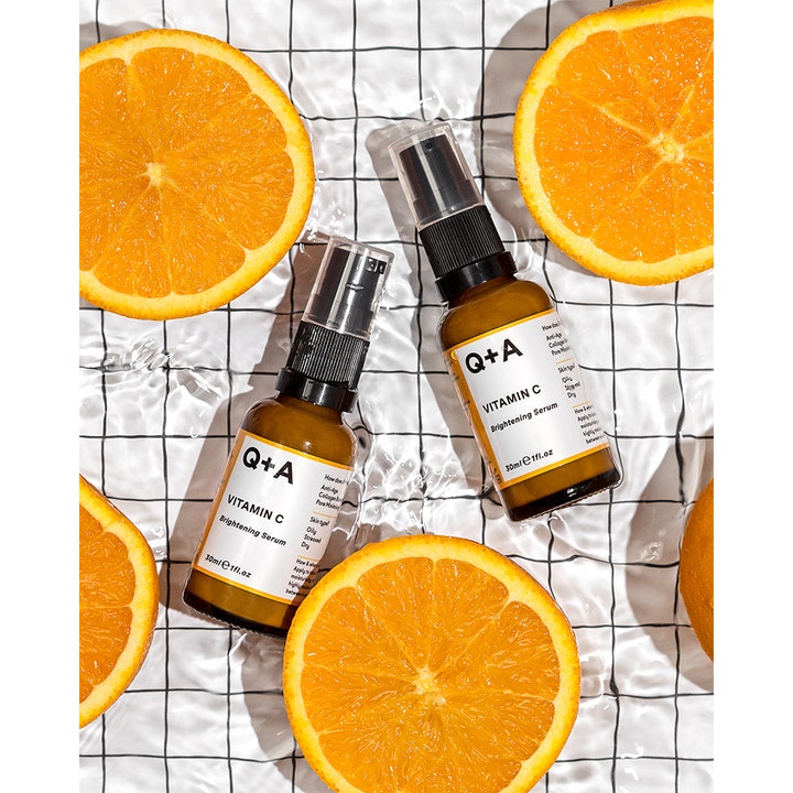 Q+A Vitamin C Brightening Serum 30 ml glødgivende ansiktsserum i brune glassflasker med friske appelsinskiver.