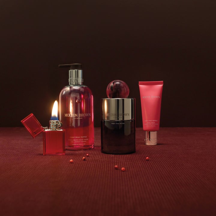 Molton Brown Fiery Pink Pepper Hand Cream 40 ml fuktighetsgivende håndkrem i rosa tube ved en tent flamme