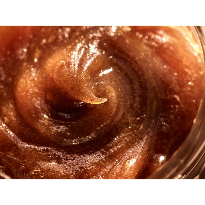Rudolph Care Acai Body Scrub 200 ml gir glød med en eksfolierende og glitrende brun tekstur i krukke.