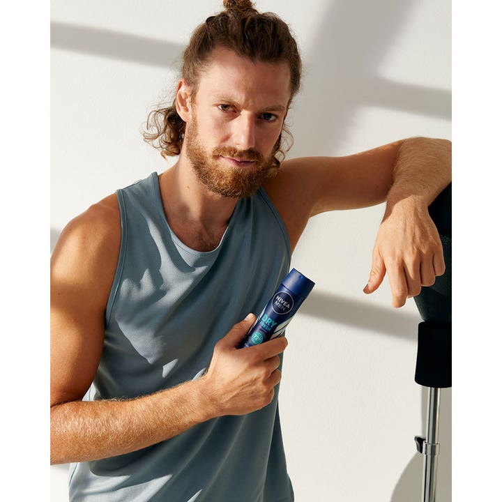 NIVEA MEN Dry Fresh Deospray 150 ml herredeodorant som gir 72 timers beskyttelse holdt av en mann i grå singlet.