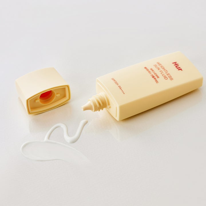 House of Hur Weightless Sun Fluid 50 ml beskyttende dagkrem med SPF 50 og hvit flytende tekstur ved beige tube