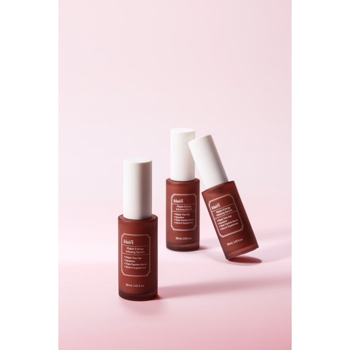Klairs Maple Energy Infusing Serum 30 ml gir glød og spenst i tre brune frostede glassflasker på rosa bakgrunn.