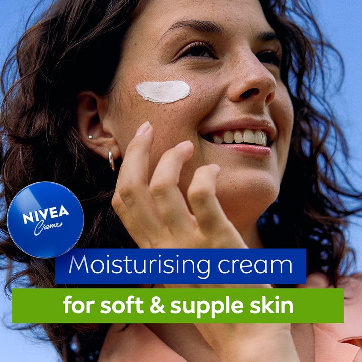 NIVEA Creme 250 ml fuktighetsgivende krem som gir myk og smidig hud vist med hvit krem på kinnet til en kvinne