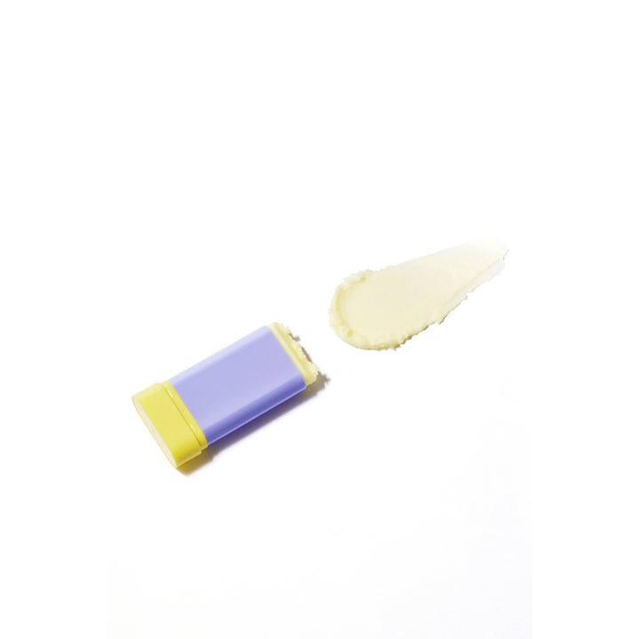 By Wishtrend Pore Smoothing Bakuchiol Sun Stick 18 g solstift med kremet teksturprøve ved siden av lilla hylse.