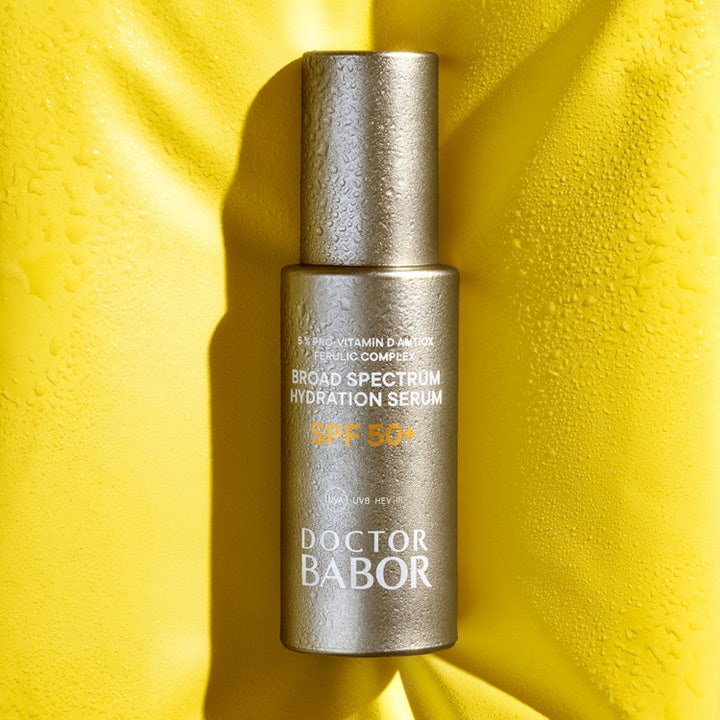 Babor DOC Broad Spectrum Hydration Serum SPF 50+ 30 ml fuktighetsgivende serum i gyllen flaske på gul bakgrunn