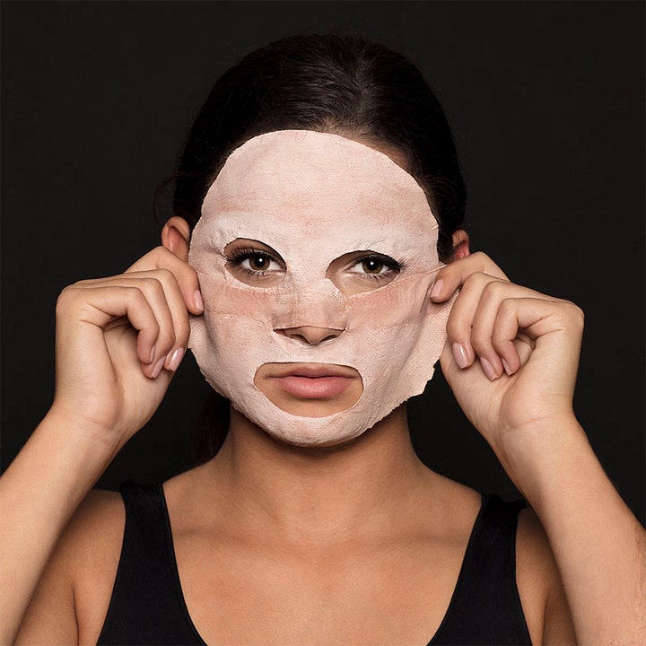 Starskin Silkmud Pink Clay 16 g rensende ansiktsmaske viser en kvinne som påfører den rosa leiremasken i ansiktet.