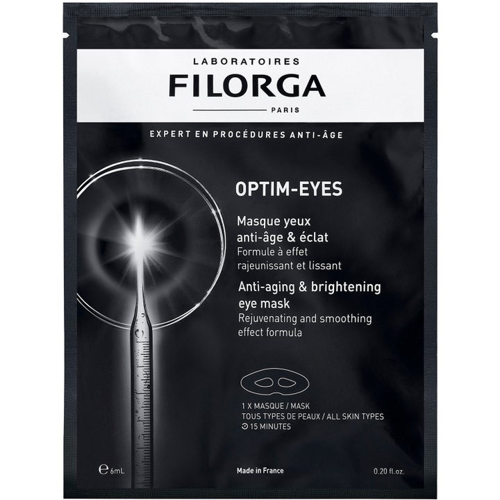 Filorga Optim-Eyes 6 ml øyemaske som gir glød i svart sachet med hvit tekst og illustrasjon av en lysende pipette